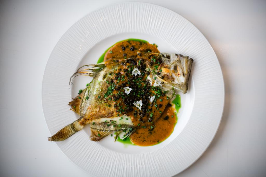 Whole fish served with a rich sauce and fresh herbs
