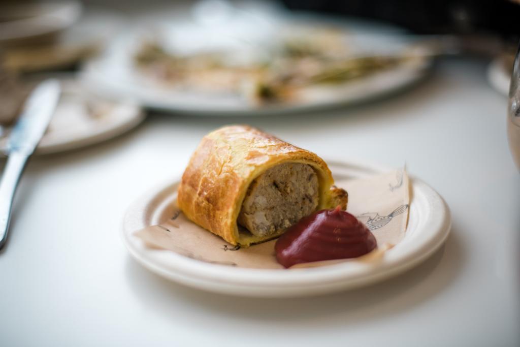 A slice of golden filled pastry served with deep red purée on a small plate